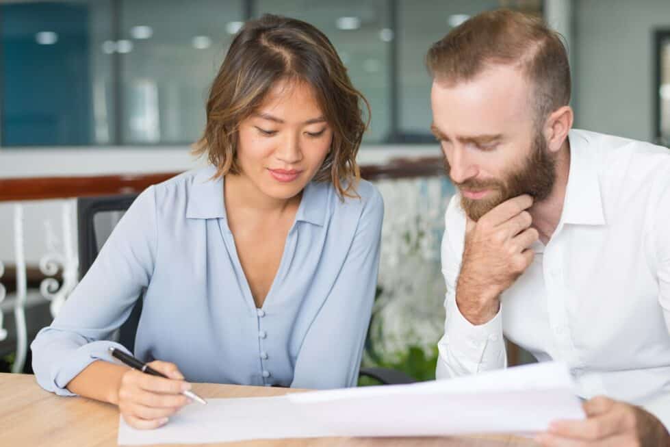 homme et femme en train d'étudier des documents